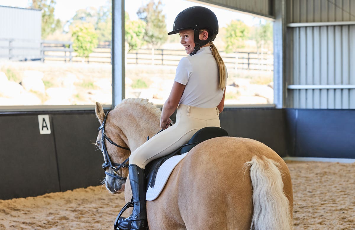 Young girl riding a pony while wearing new Dublin clothing