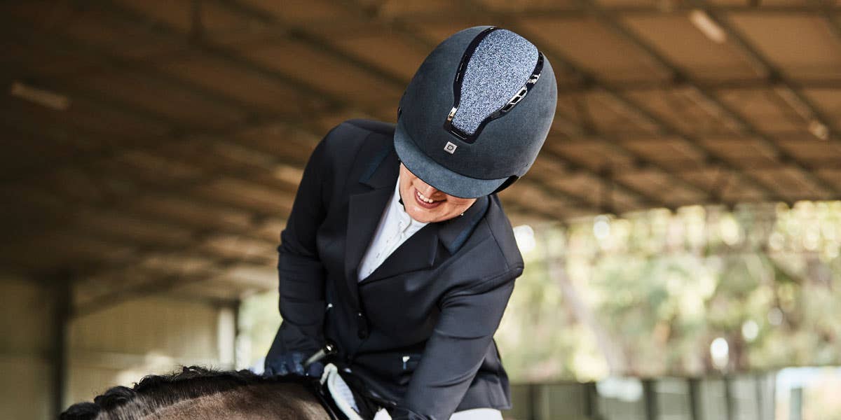 Rider patting her horse wearing the Dublin Adara Shimmer Helmet